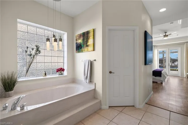 Bathroom featuring tile patterned flooring, ceiling fan, and a bathtub