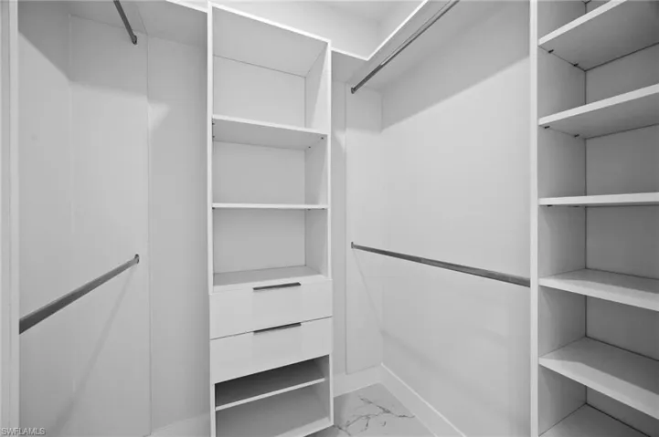 Walk in closet with light marble finish flooring