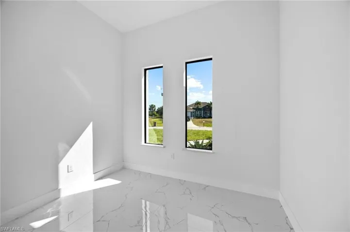 Unfurnished room with light marble finish flooring and baseboards