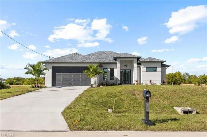 Prairie-style house featuring stucco siding, an attached garage, a front lawn, and concrete driveway