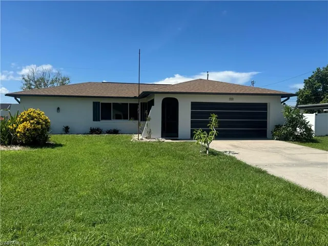 Single story home featuring a garage and a front yard