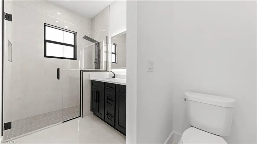 Bathroom featuring vanity, a stall shower, and light tile patterned floors