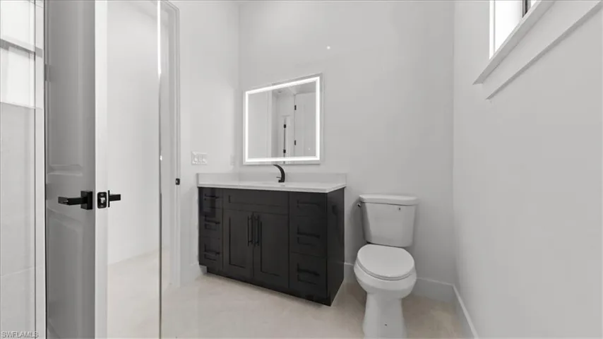 Half bath featuring vanity and light tile patterned floors