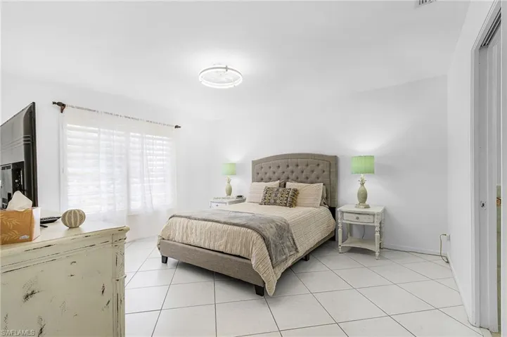 Bedroom featuring light tile patterned floors and baseboards