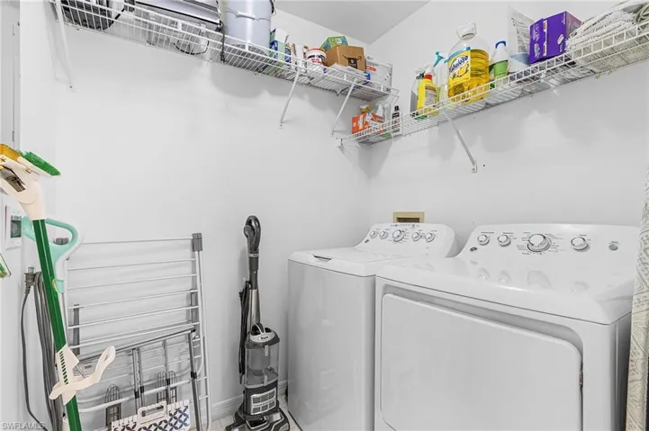 Laundry area with washing machine and clothes dryer and baseboards