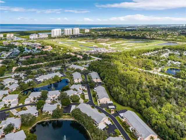 Aerial view of property and surrounding area with a large body of water and nearby suburban area