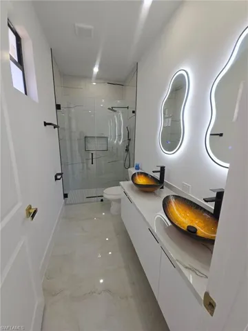 Unfurnished bedroom featuring a walk in closet, recessed lighting, light marble finish floors, and a ceiling fan