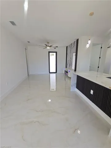 Spare room featuring light marble finish flooring and ceiling fan