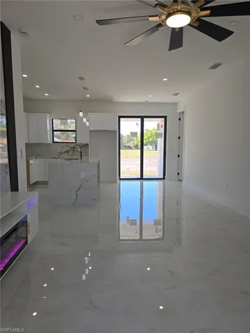 Unfurnished living room featuring light marble finish floors, recessed lighting, and a ceiling fan