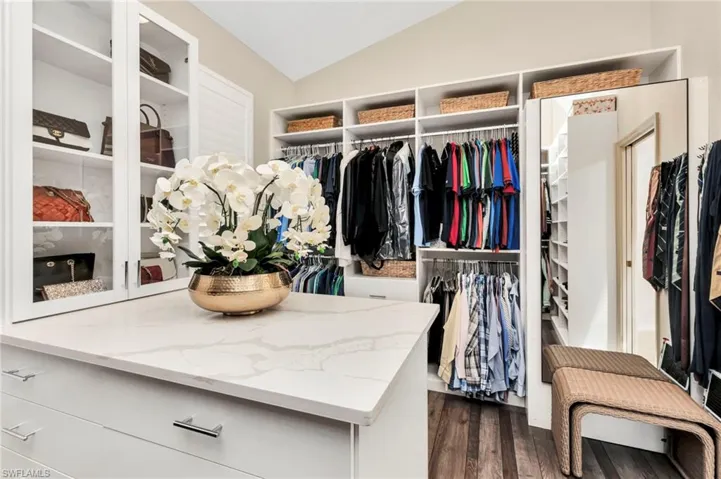 Walk in closet featuring dark wood-type flooring and vaulted ceiling