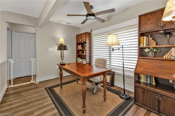 Office area featuring baseboards, visible vents, and dark wood finished floors