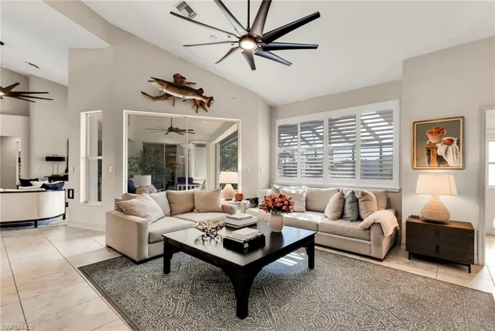 Tiled living room with vaulted ceiling and ceiling fan