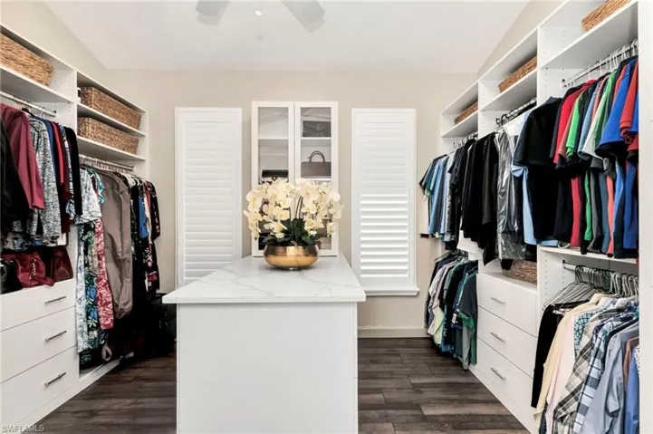 Walk in closet featuring ceiling fan and dark hardwood / wood-style floors