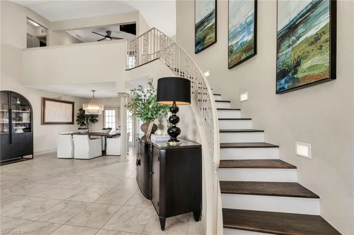 Stairway featuring ceiling fan and a towering ceiling