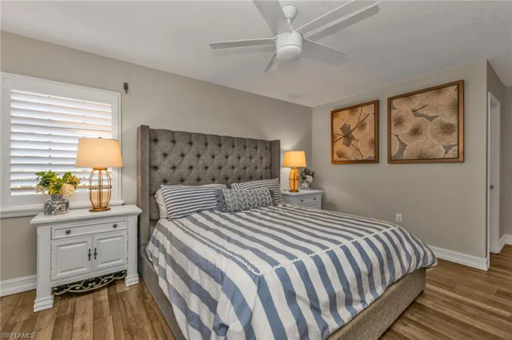 Bedroom with dark hardwood / wood-style flooring and ceiling fan