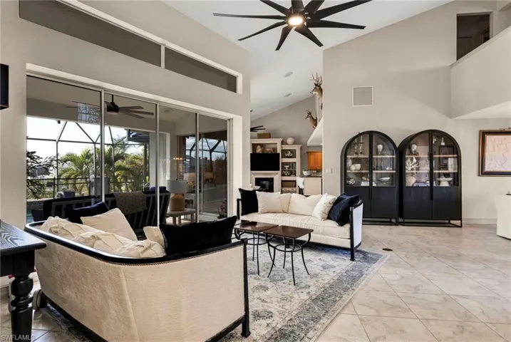 Tiled living room featuring ceiling fan and a high ceiling