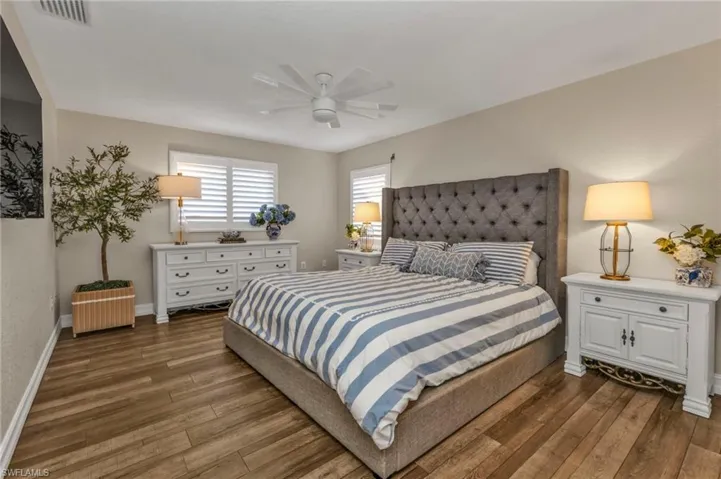 Bedroom featuring ceiling fan and dark wood-type flooring