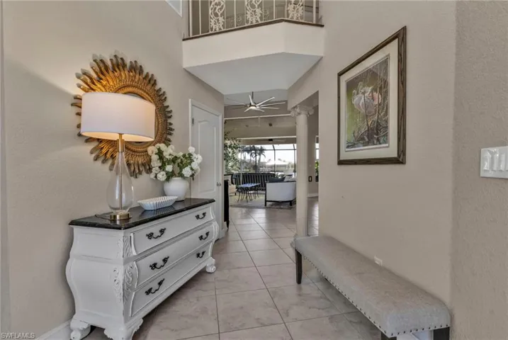 Hallway featuring light tile patterned floors and ornate columns