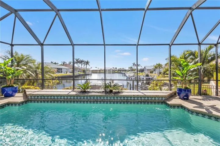 View of swimming pool with a water view, a lanai, and a patio area