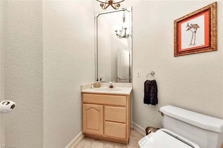 Bathroom with vanity, an inviting chandelier, and toilet