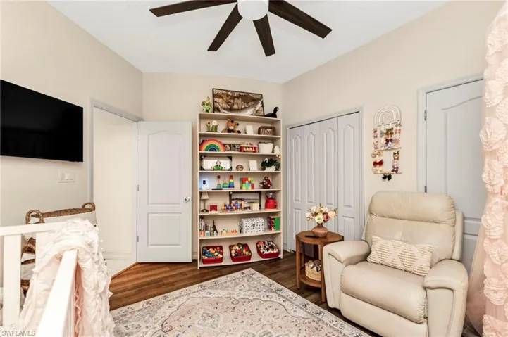 Living area with dark wood-style floors and ceiling fan