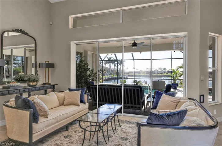 Living room with a water view, a sunroom, and ceiling fan