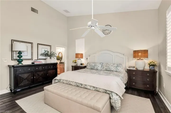 Bedroom featuring a high ceiling, connected bathroom, and dark hardwood / wood-style floors