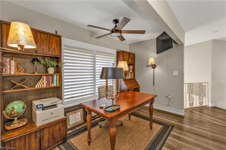 Office space featuring dark hardwood / wood-style flooring and ceiling fan