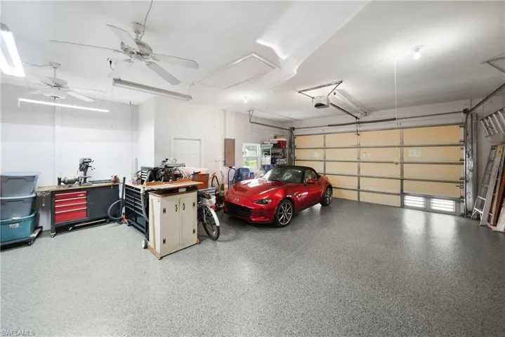 Garage featuring electric panel, ceiling fan, and a garage door opener