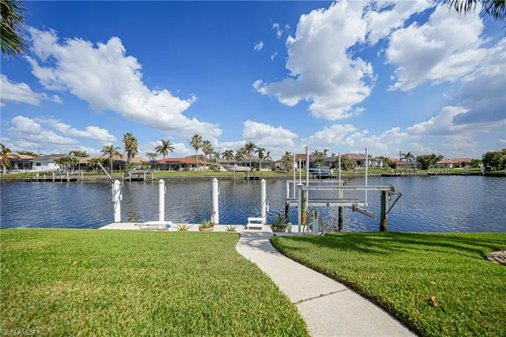 View of dock with a water view and a yard