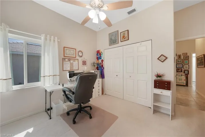 Office with light tile patterned floors and ceiling fan