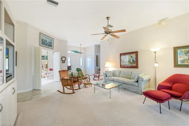 Living room with light colored carpet and ceiling fan
