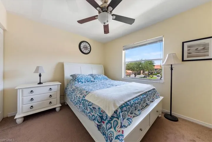 Carpeted bedroom featuring a ceiling fan and baseboards