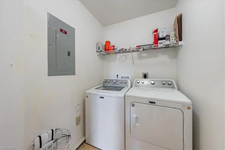 Laundry room with laundry area, washing machine and dryer, and electric panel