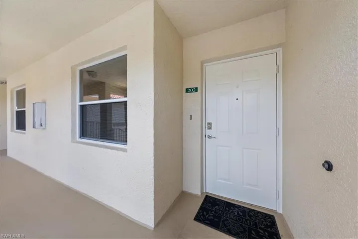 Doorway to property featuring stucco siding