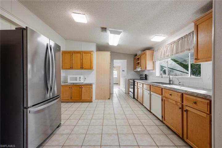 Maple cabinets, resurfaced countertops, and newer appliances.