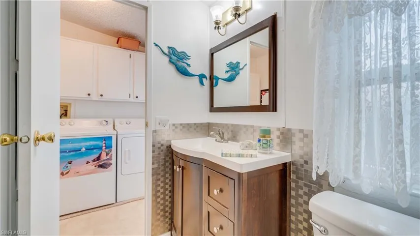 Storage space abounds in this inside laundry room complete with upper cabinetry and room for a desk or craft space.