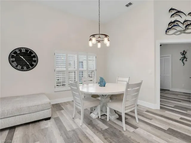 Dining room with high vaulted ceiling and custom lighting