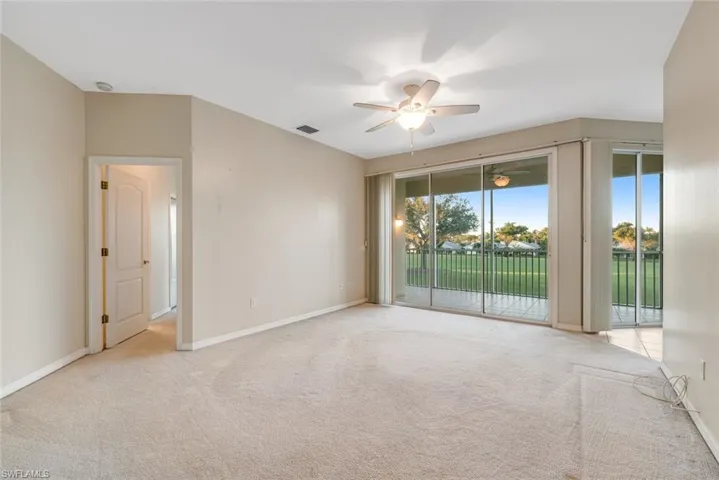 Spare room featuring light carpet and ceiling fan