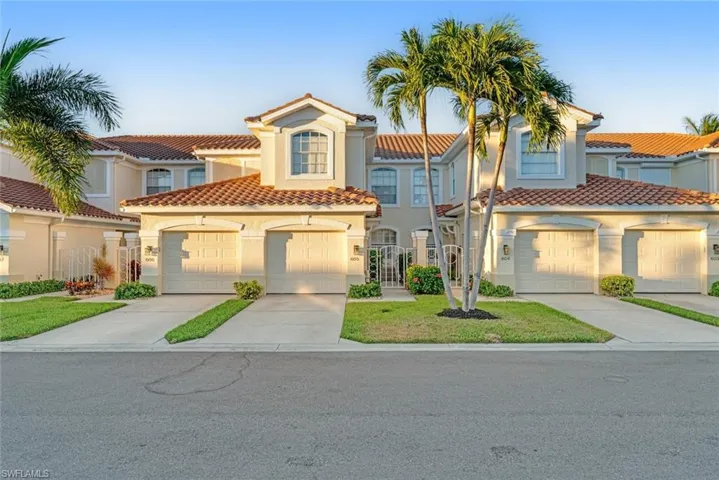 Mediterranean / spanish-style house featuring driveway, stucco siding, a tiled roof, and a front lawn