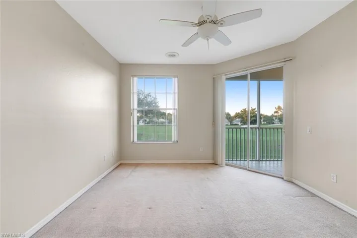 Carpeted empty room featuring a ceiling fan and baseboards