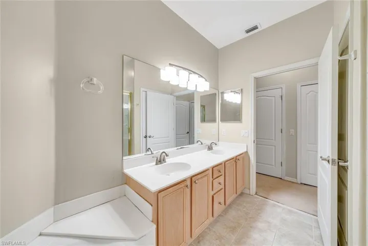 Full bath featuring double vanity and light tile patterned flooring