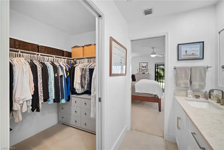 Walk in closet with light colored carpet