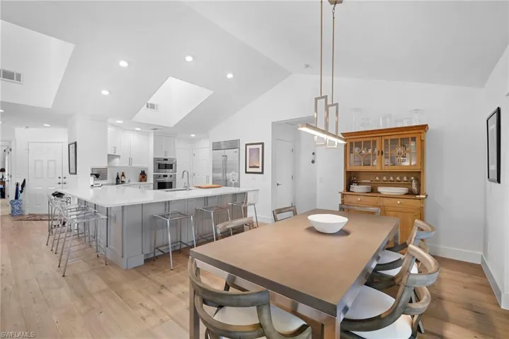 Dining area with light wood-type flooring and a high ceiling