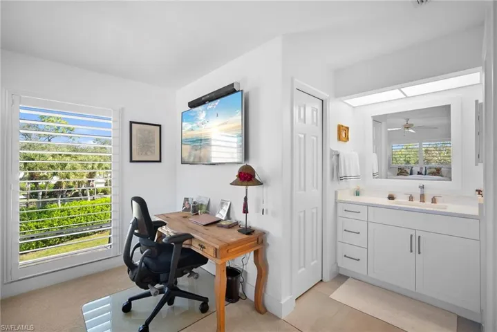 Office area with light carpet and ceiling fan