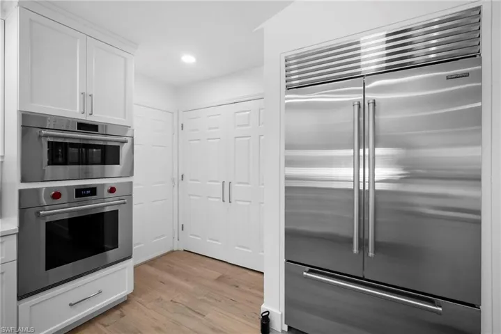 Kitchen featuring stainless steel appliances, white cabinetry, light wood finished floors, recessed lighting, and light countertops
