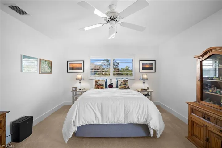 Carpeted bedroom featuring a ceiling fan and baseboards