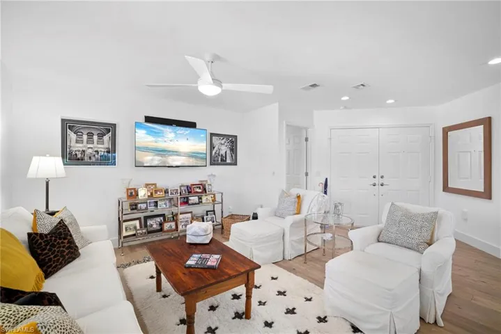 Living room featuring wood finished floors, ceiling fan, and recessed lighting