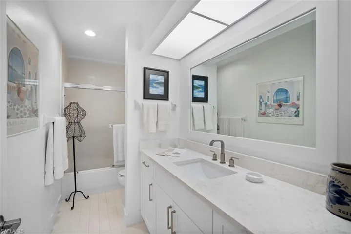 Bathroom with vanity, bath / shower combo with glass door, and recessed lighting