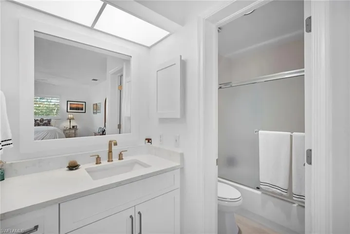 Full bath with ensuite bathroom, bath / shower combo with glass door, and vanity
